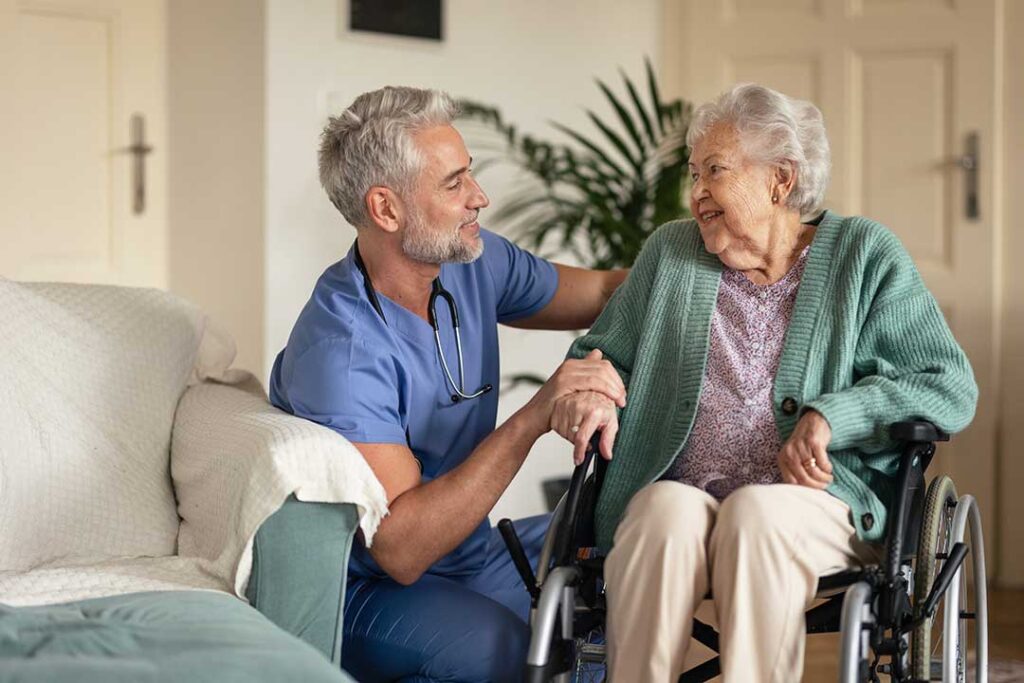 Older adult and family member reviewing care options with a caregiver in a bright residential living room.