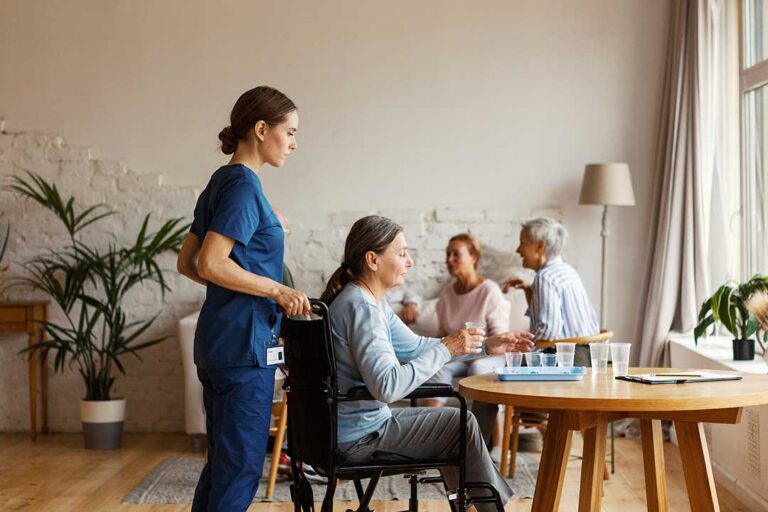 Two older adults independently preparing a small meal together in a bright communal kitchen.